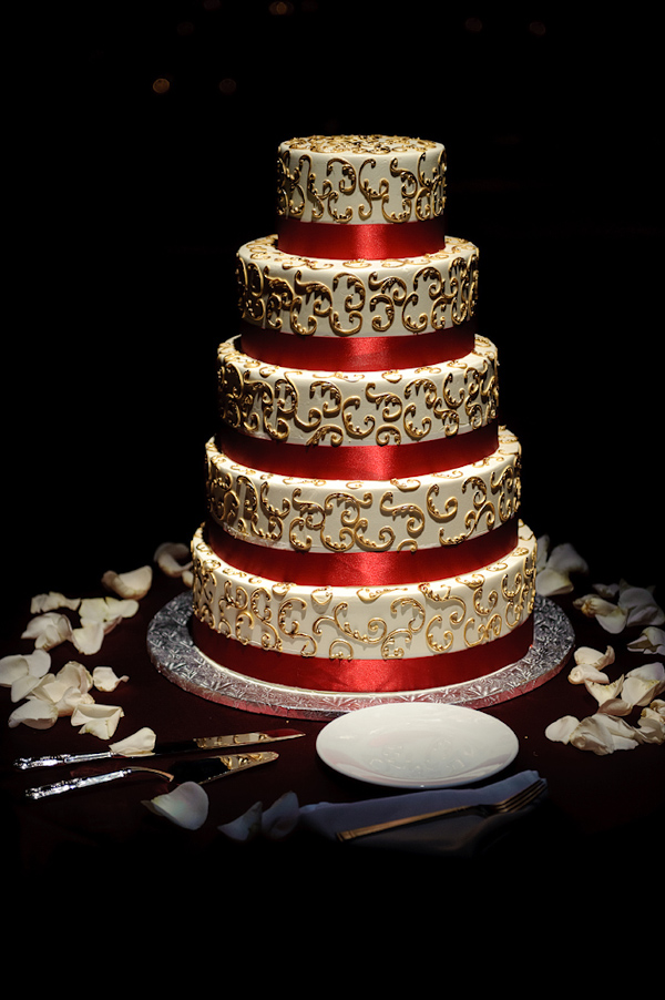 Five layer white, gold, and red wedding cake - photo by Kenny Nakai Photography